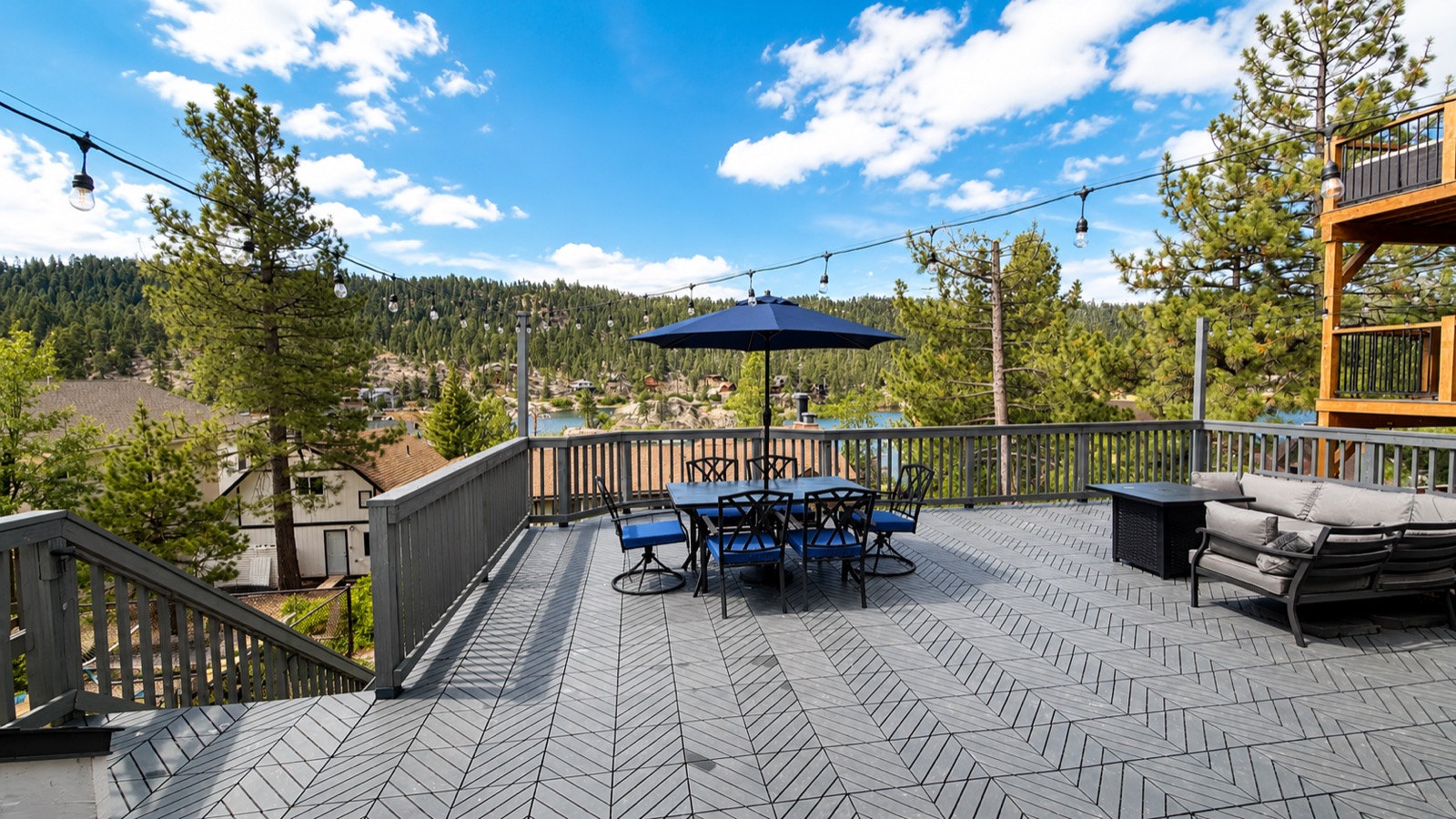 Rooftop deck with dining table, lounge seating, and lake view